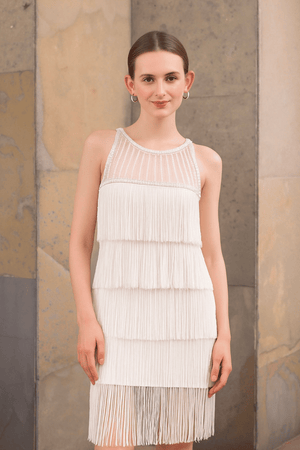 Close-up of fringe and sequin detailing on white dress