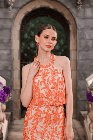 Model wearing coral hand-beaded halter dress – front view