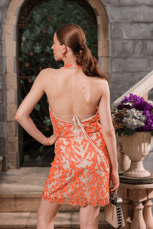Back view of coral hand-beaded dress with halter neckline