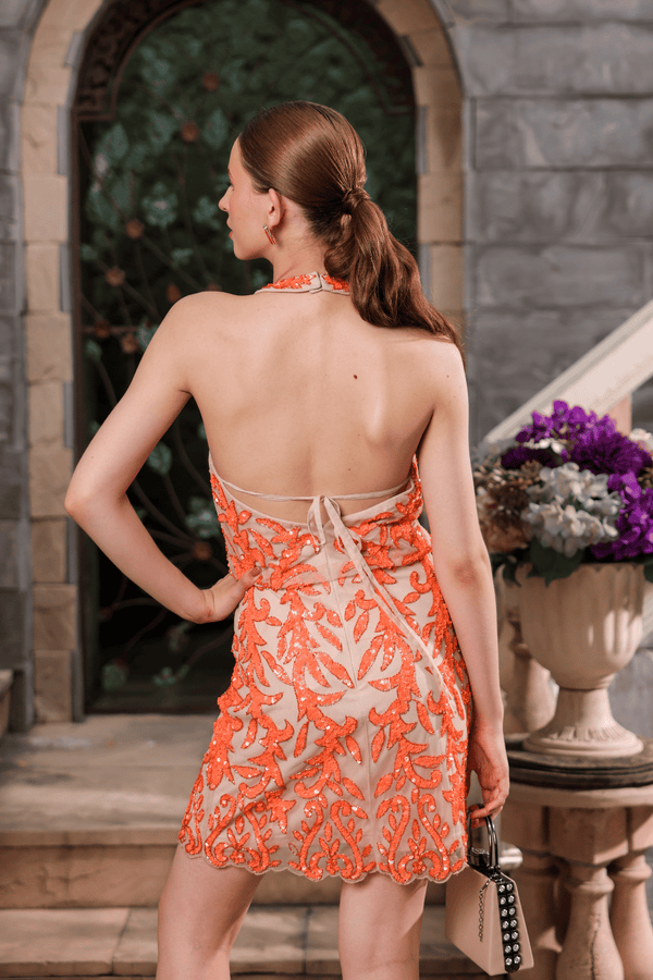 Back view of coral hand-beaded dress with halter neckline