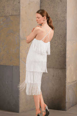 Model in white beaded fringe dress posing in motion – party-ready styling