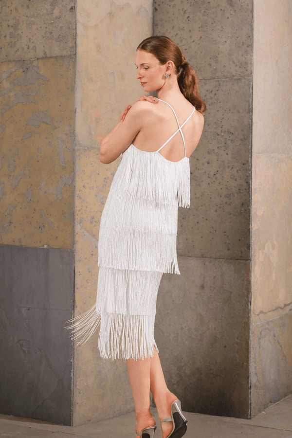 Model in white beaded fringe dress posing in motion – party-ready styling