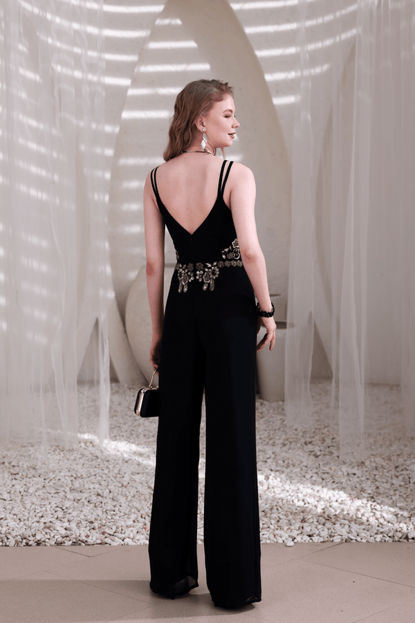 Side view of black jumpsuit showing hand-beaded waist and flowy leg cut
