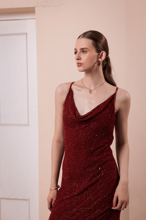 Close-up of beaded embellishment on wine red satin fabric