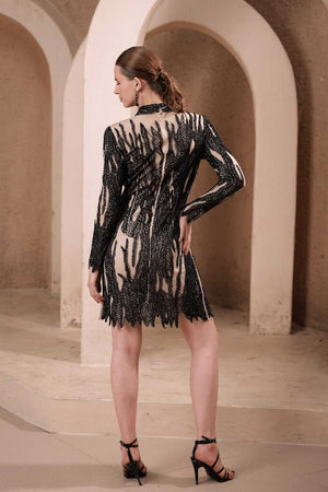 Back view of Edition Two black flame beaded illusion dress – illusion mesh back and jagged hemline with beaded fringe detail