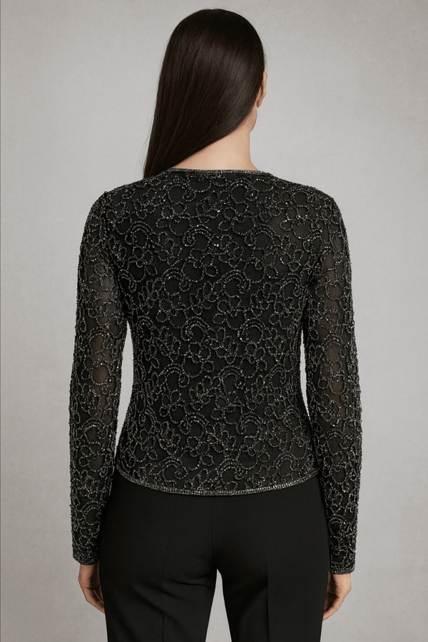 Back view of ivory lace cape paired with black outfit – showcasing embroidery and cape fall