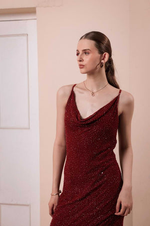 Close-up of beaded embellishment on wine red satin fabric