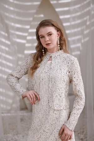Flat lay of ivory hand-beaded shrug highlighting lace detail and structure